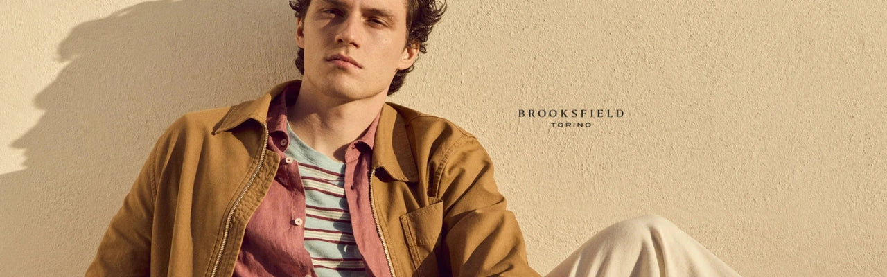 Modello che indossa abbigliamento Brooksfield su sfondo beige